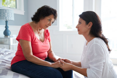 Caregiver comforting senior woman at home