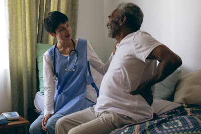 Asian female doctor and African-american senior male patient interacting with each other