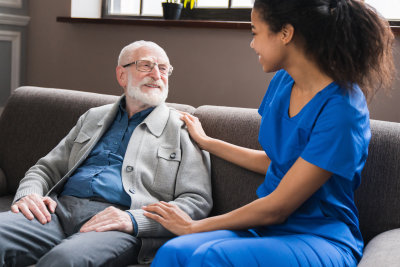 Caring nurse talking to old senior man